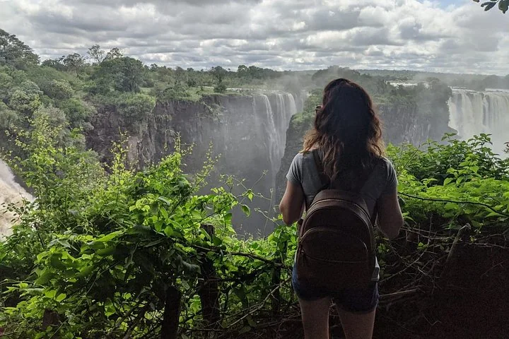 Mujer con una mochila contemplando las Cataratas Victoria.