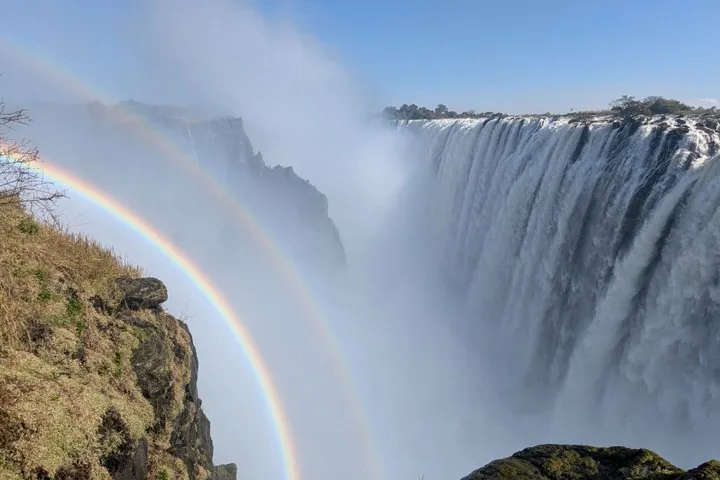 Atemberaubender Doppelregenbogen, der sich im Nebel an den Victoriafällen bildet.